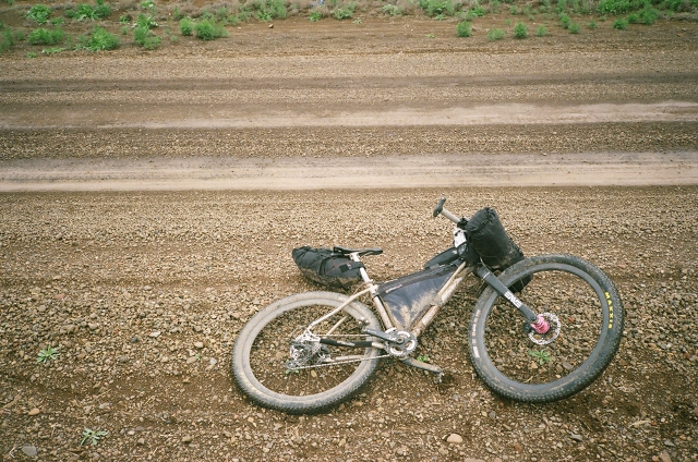 Dan's bike lying on the side of a dirt road