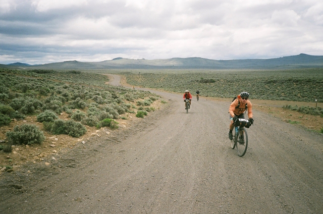 Cyclists riding an endless dirt road