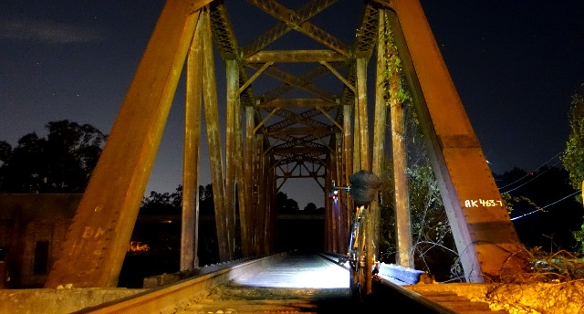 a bike leans against a railroad trestle