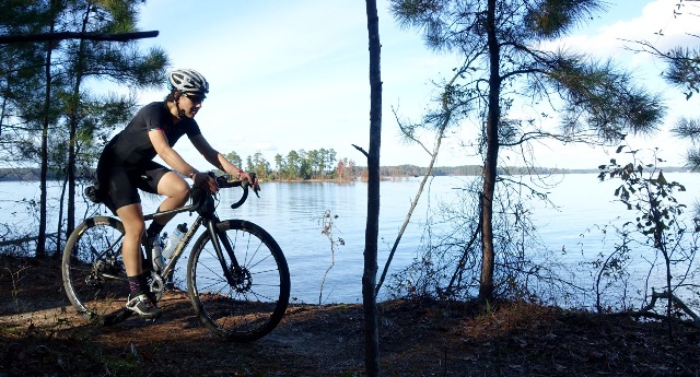 A cyclist rides along the river
