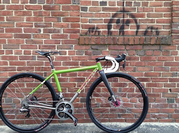 Green Axiom leaning on a brick wall