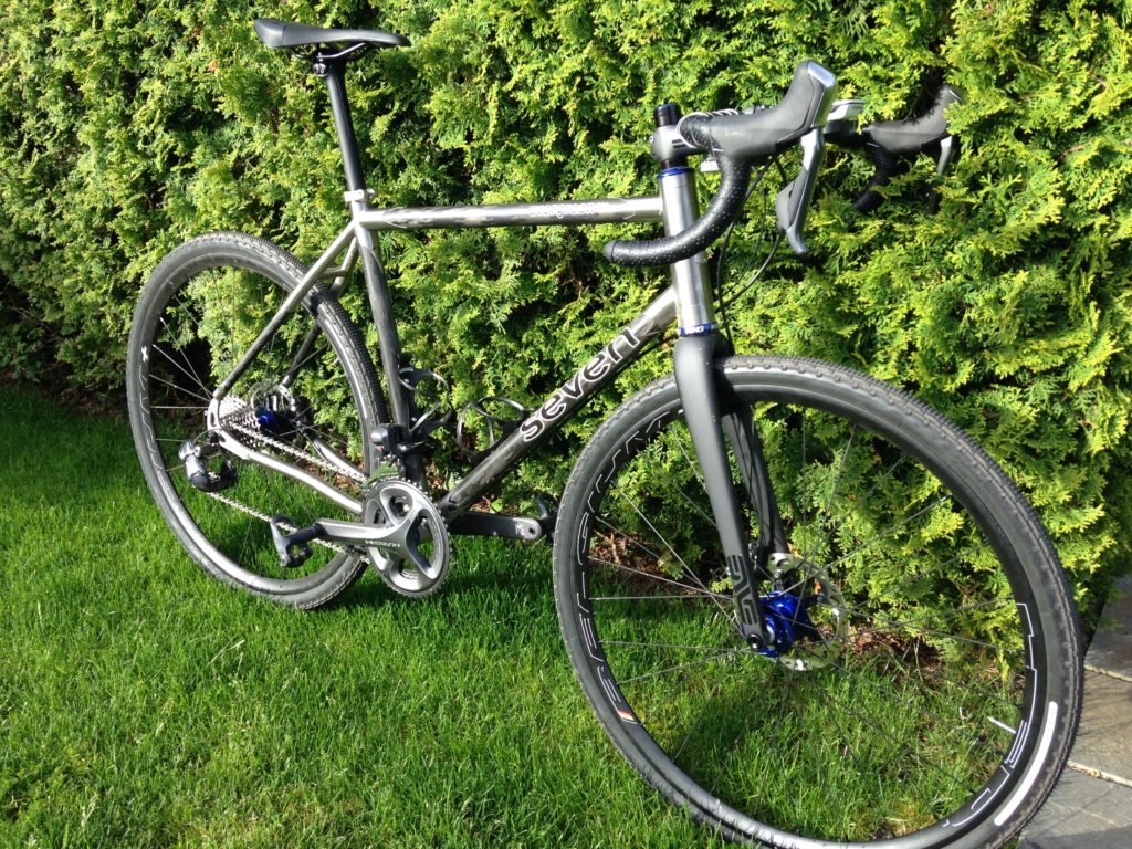 a pristine Seven Evergreen PRO leans against a very greem shrub on a nice lawm