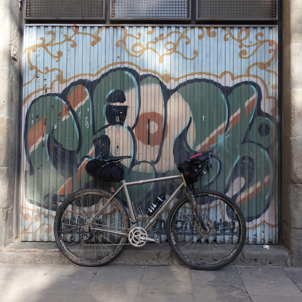 A well-equipped Seven Evengreen leans against a wall painted with beautiful grafitti