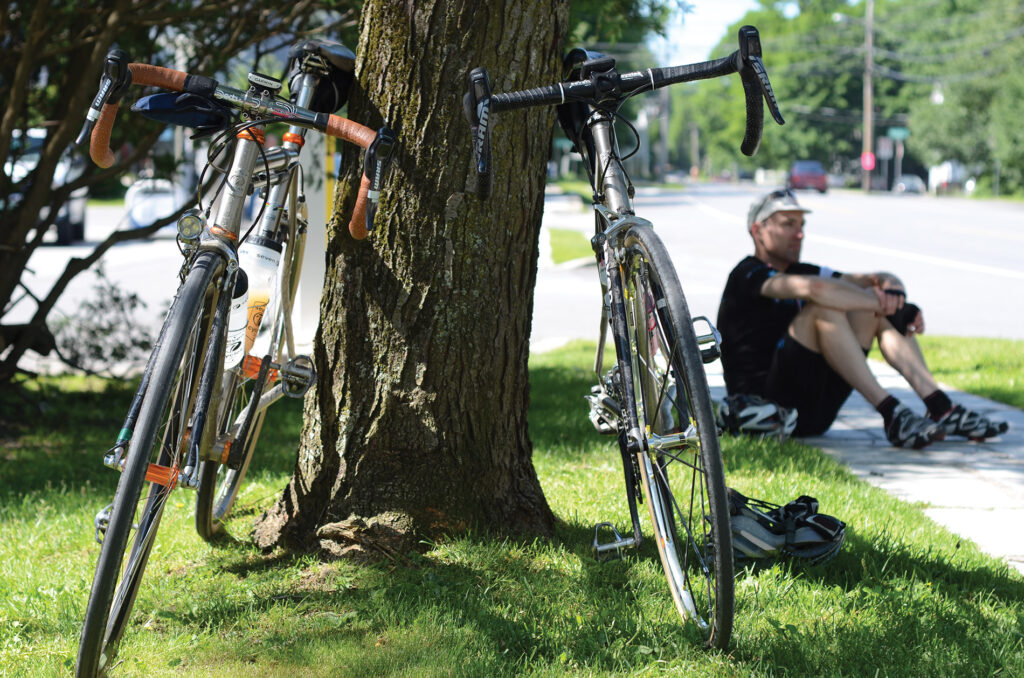 two bikes against a tree with blurry rider in the background