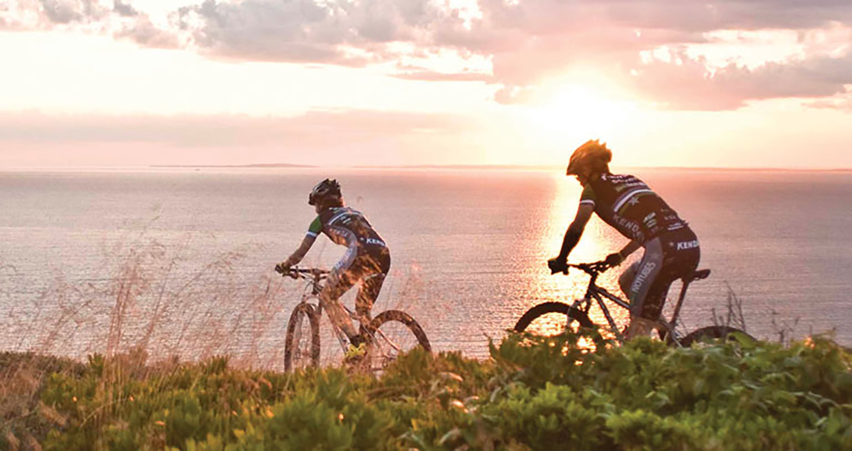 Mike Broderick and Mary McConnenoug ride their Solas into the Sunrise near the ocean