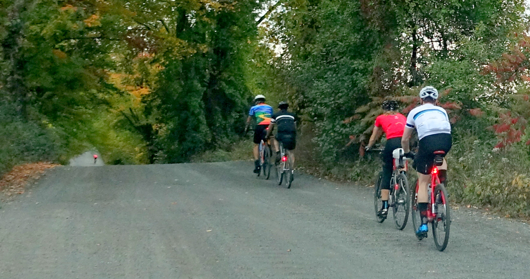 four cyclists on a rolling gravel road